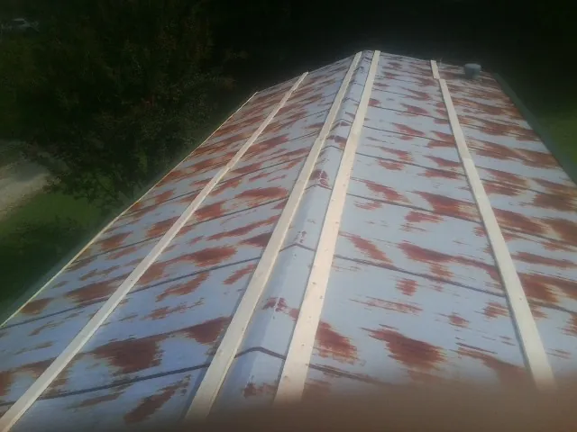 Rusted metal roof panels with new wood purlins before replacement — Storm Damage Roof Repair in Valley by Roofing Brothers
